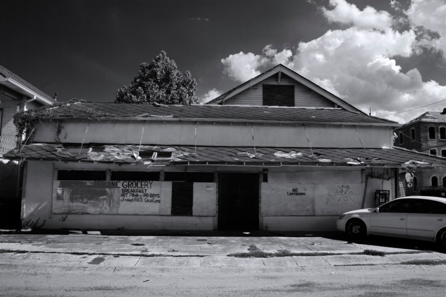 A black and white image of a dilapidated grocery store, Leblanc Grocery, in the Treme neighborhood of New Orleans, LA